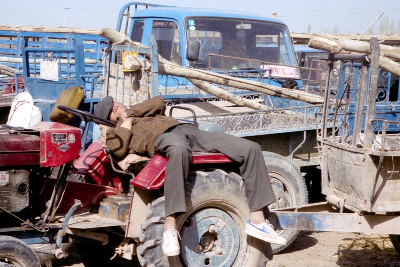 Un homme fait la sieste sur son tracteur.